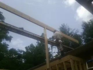 Carpenter setting a ridge beam over a new addition frame — Ice Dam Removal by Roofing Brothers in Bantry