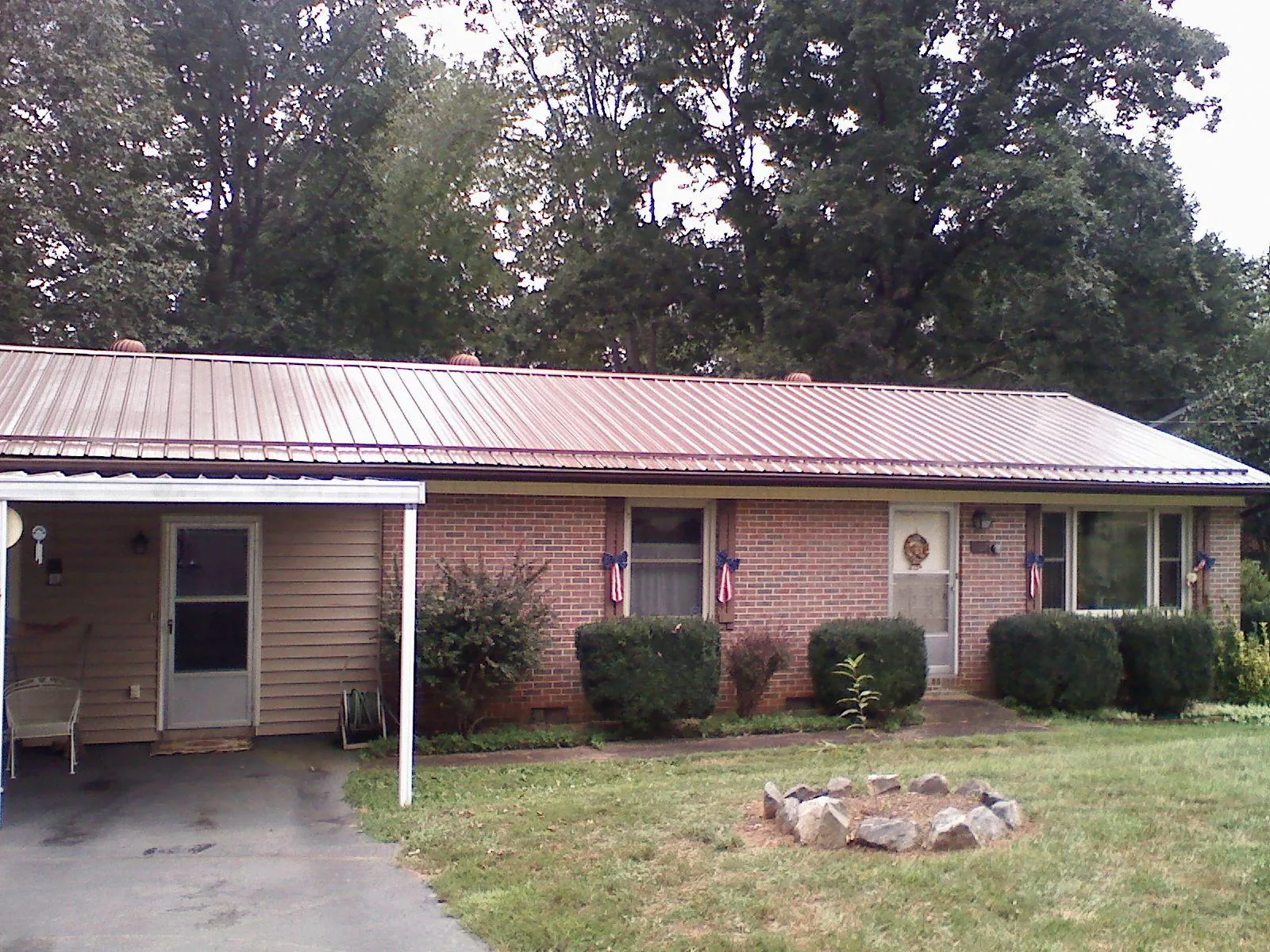 Bronze metal roof and carport on a brick ranch home — Roof Repair work by our crew in Bantry